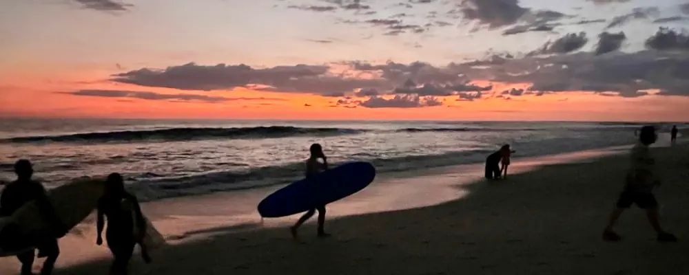 surfers at sunset in the beach of mal pais